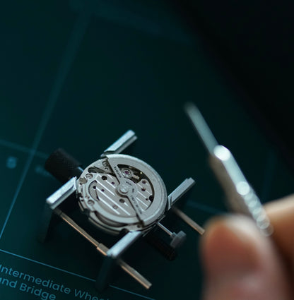 Miyota 82S0 movement held in a holder, resting on the printed lesson guide